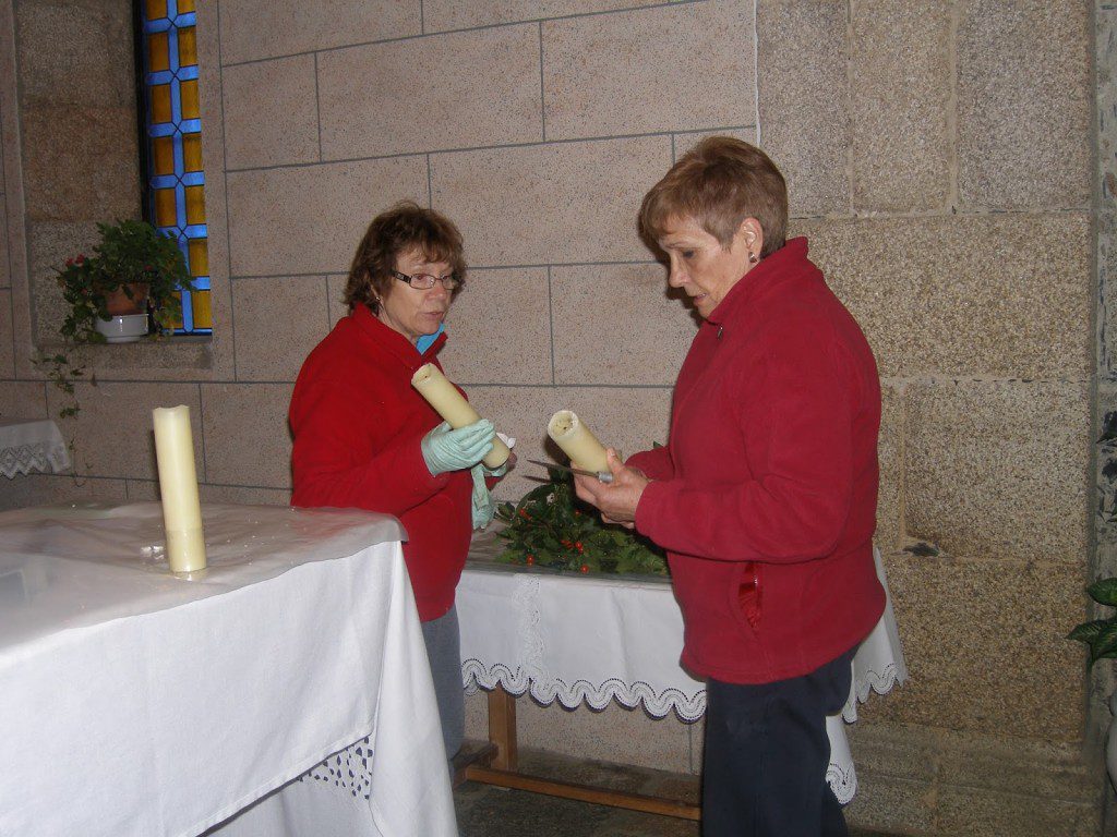 Mujeres elaborando una corona de plantas en la iglesia