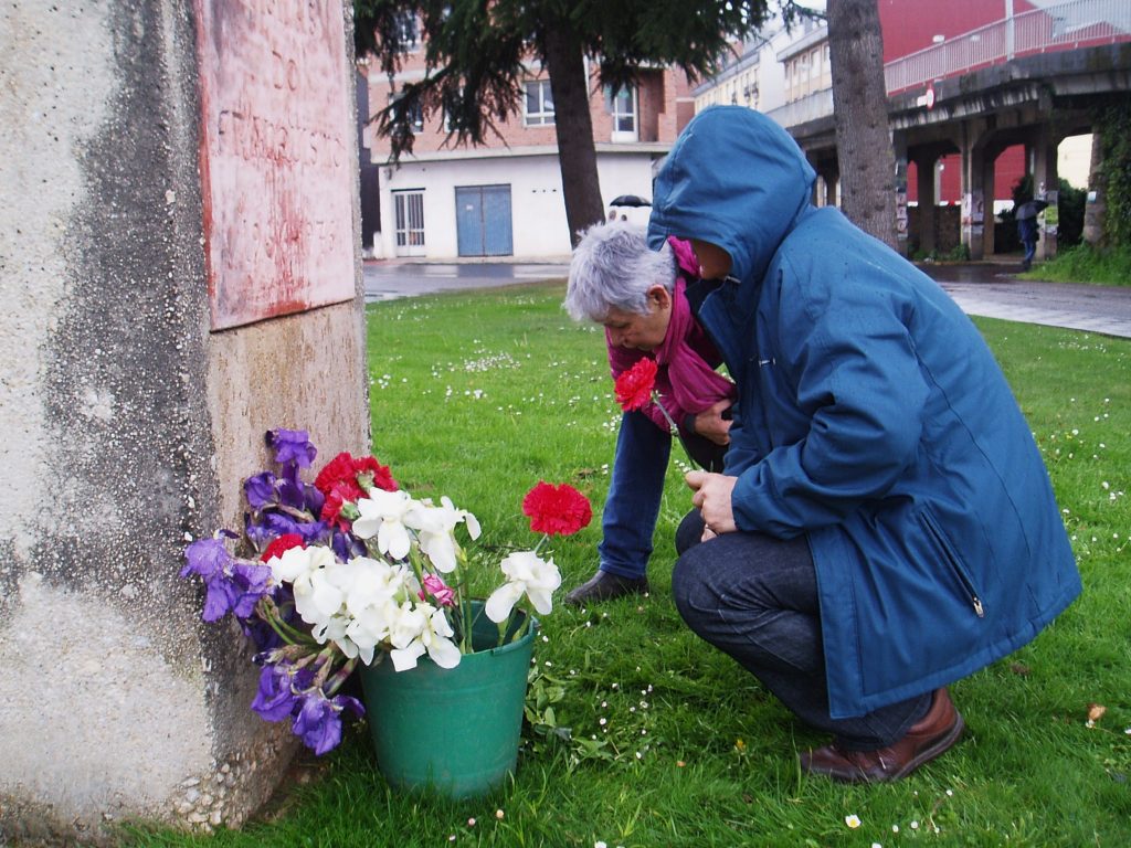 Con flores al pie de la escultura que recuerda a las víctimas del franquismo