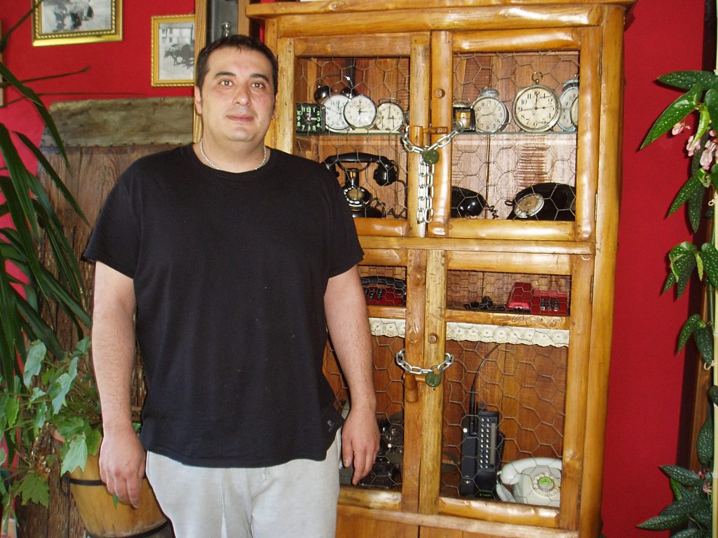 Nicolás González Ribalonga junto a la colección de relojes y teléfonos antiguos