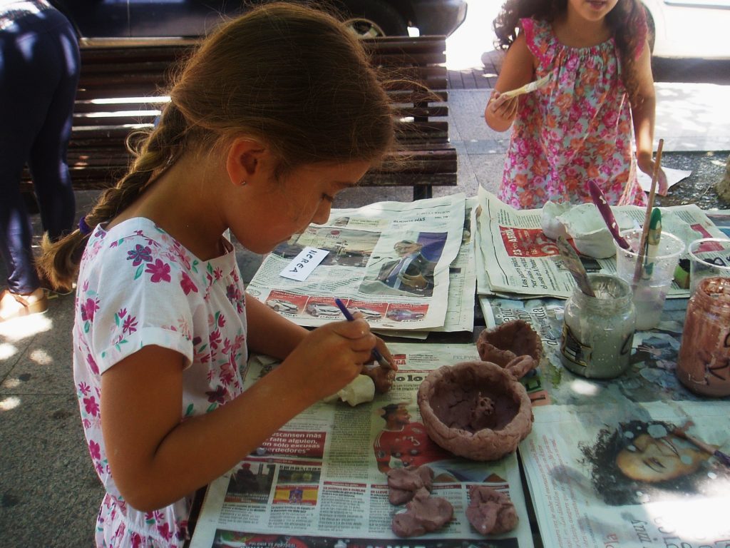Una niña muy concentrada con su cuenco de cerámica