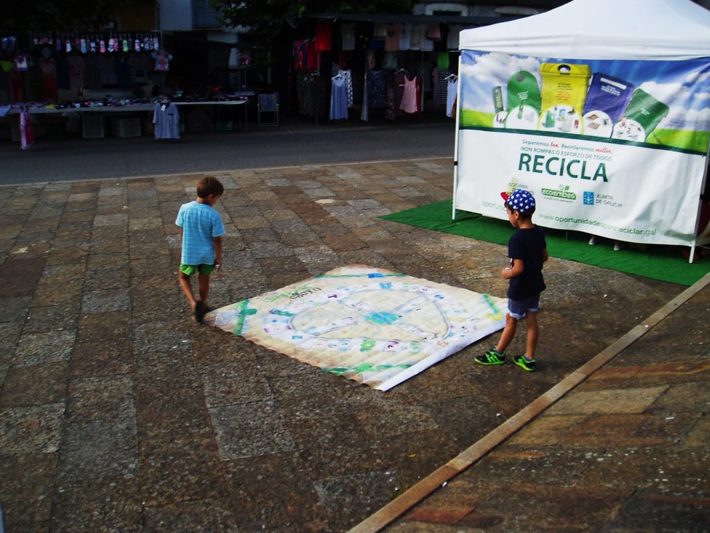 Niños sobre el parchís de reciclaje
