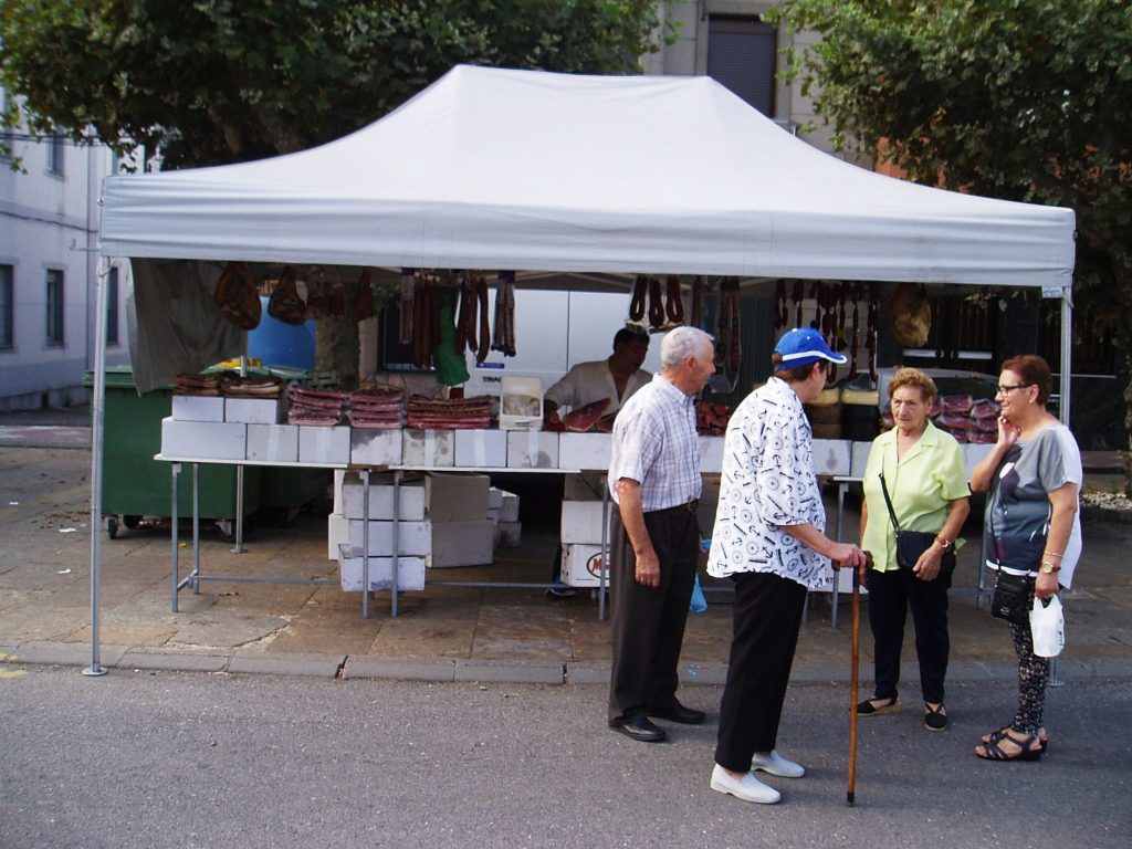 Vecinos de Vilamartín charlan después de comprar en la feria