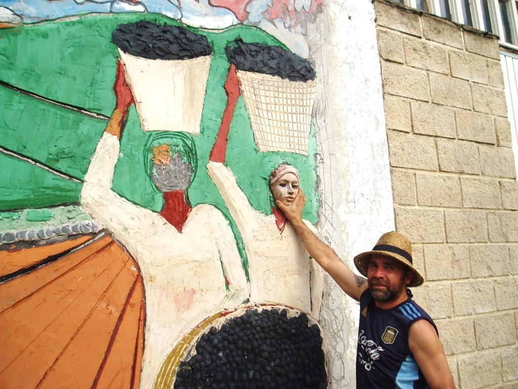 Leonardo Corazza prueba una de las caras de cerámica sobre el mural
