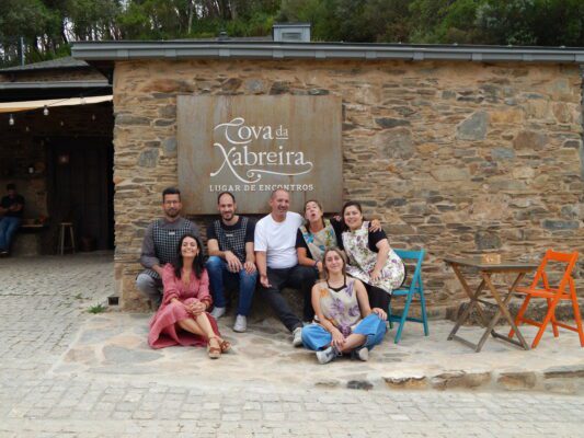 Equipo de trabajo de A Cova da Xabreira posando en su cartel