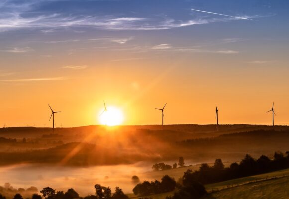 Puesta de sol tras loma con aerogeneradores